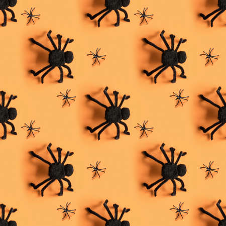 Black spiders on orange. View from above. Open composition. Halloween party pattern.
