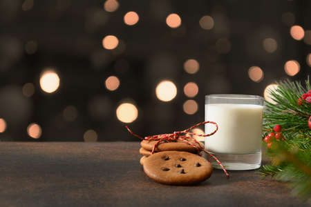 Christmas cookies and glass of milk for Santa near Xmas tree.の写真素材