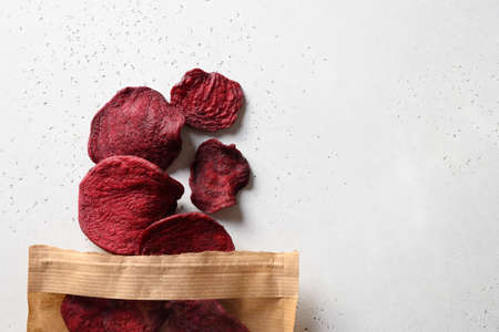 Vegetable beetroot chips in paper craft package on a white background.の写真素材