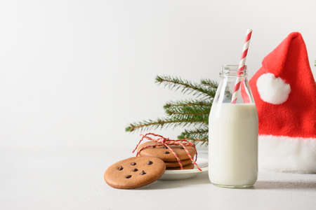 Milk for Santa Clause and cookies on white table background. Copy spaceの写真素材