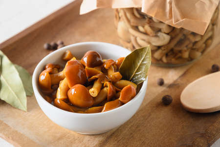 Pickled honey mushrooms served with bay leaf in bowl.の写真素材