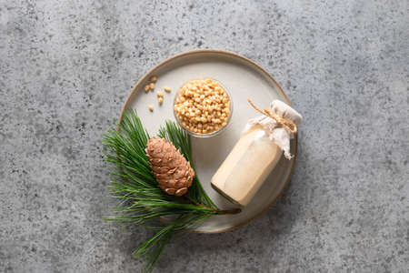 Vegan cedar nut milk in bottle on gray background. Non dairy alternative milk. Healthy vegetarian drink. Copy spaceの写真素材