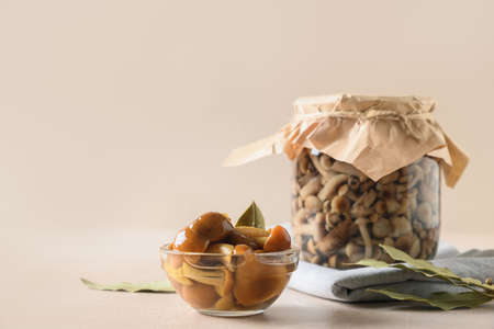 Pickled honey mushrooms served in bowl with bay leaf.の写真素材
