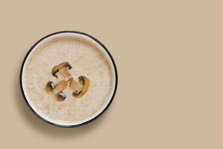 Mushroom champignon cream soup on beige background. View from above.の写真素材