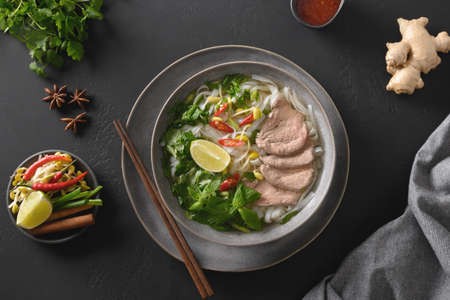 Pho Bo Soup with beef in bowl on black background. Vietnamese cuisine.の写真素材