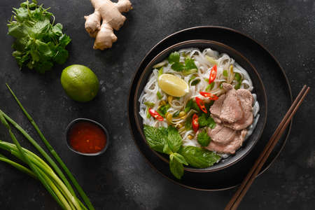 Pho Bo Soup with beef in bowl on black background. Vietnamese cuisine.の写真素材