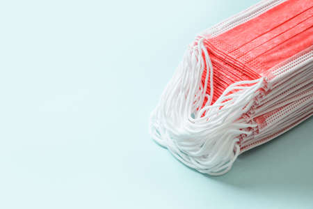Pile of red medical face mask on a blue background.の写真素材