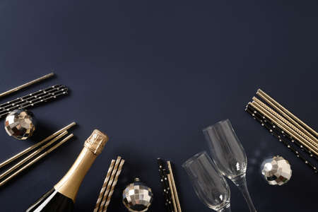 Composition with New Year champagne, drinking straws, disco balls on blue. Greeting cardy.の写真素材