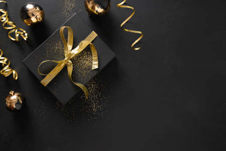 Gold and black gift and baubles with Christmas decorations.の写真素材