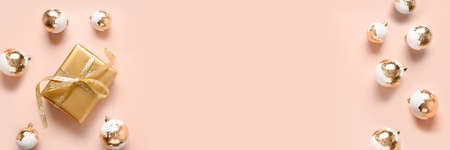 Christmas banner with gold gift and white baubles on pink background.の写真素材