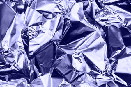 Crumpled very peri or violet foil background. Abstract pattern.