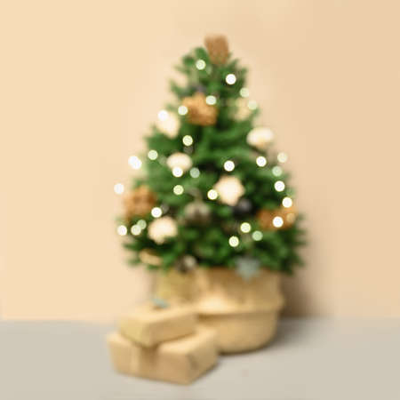 Blurred Christmas tree with gifts on beige background.の写真素材