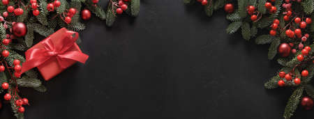 Christmas frame with red gift and decorations on black. Xmas greeting card.の写真素材