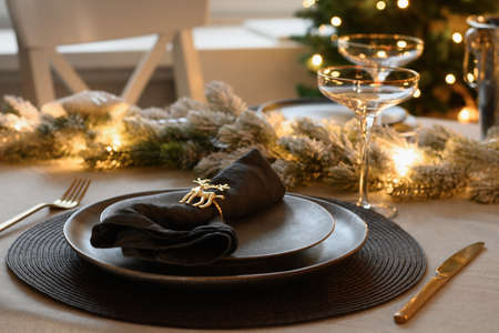 Christmas festive table setting, gold decorate and champagne. Family holiday dinner or New Year party.の写真素材