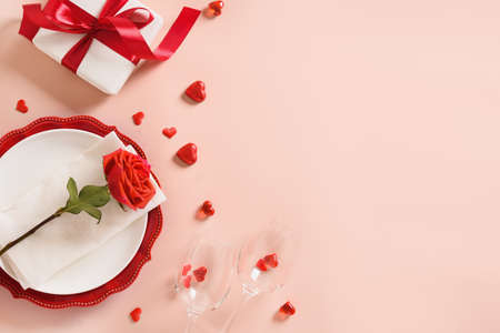Valentines day table place setting with gift, a bottle of red wine, roses, hearts.の写真素材
