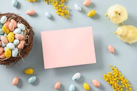 Easter mock up with pastel chocolate eggs on blue background.