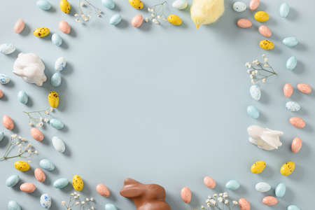 Easter mock up with pastel chocolate eggs on blue background.