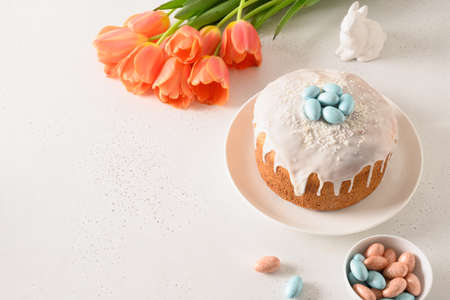 Composition with Easter cake , rabbit and chocolate eggs , spring tulips