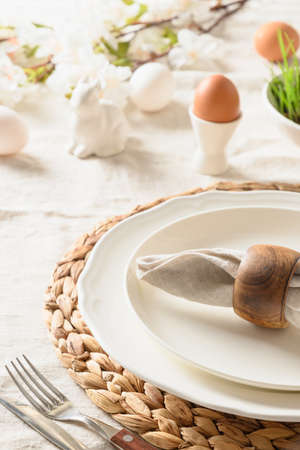 Easter table setting with blue coloful eggs, festive decorations, fresh flowers.の写真素材
