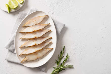 Smoked halibut slices on white background. View from above. Copy space.