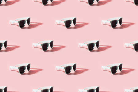 Seamles pattern of sun glasses with sunny shadow on pink background. Summer concept.の写真素材