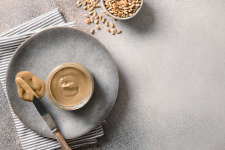 Sunflower seeds butter in glass jar. Allergy-free alternative to peanut butter. Food trend. View from above. Copy space.の写真素材