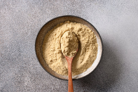 Sesame flour in bowl on gray background. Cooking gluten-free and low carbohydrate dessert. Good source of protein. View from above.の写真素材