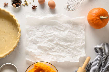 Process of making Pumpkin pie for Thanksgiving Day on white kitchen background. Seasonal traditional autumn festive cake. Top view.の写真素材