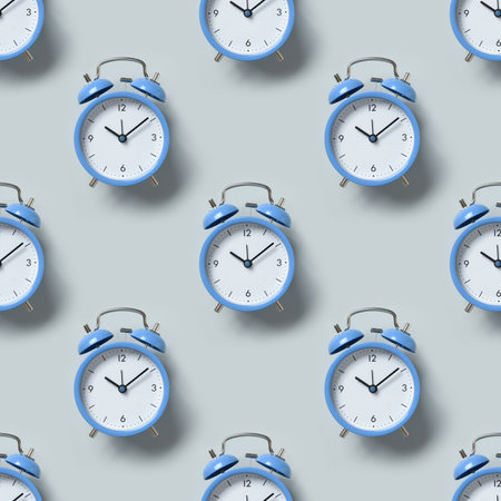 Seamless pattern of old-fashioned blue alarm clocks on blue background. Flat lay.の写真素材
