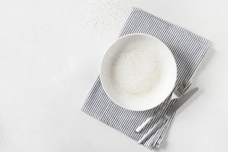 White empty plate with silver cutlery on white background. Kitchen and cooking template, mock up....