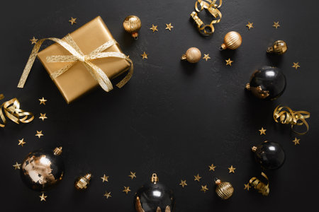 Shiny black balls and golden gift with on black background. Happy New Year.