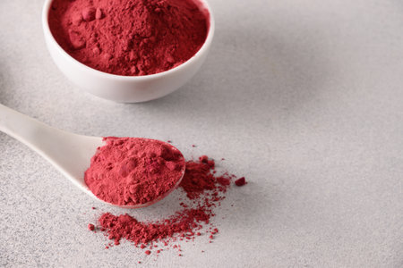 Beetroot powder for cooking healthy beverage in spoon on gray background. Close up.の写真素材