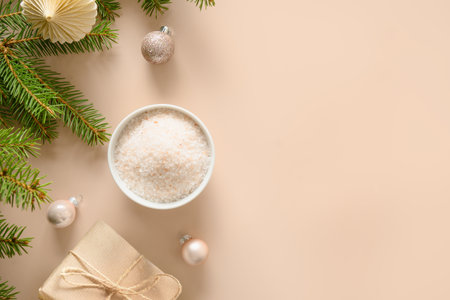 Winter body skin care and Christmas Spa concept and preparation before holiday. Cosmetic sea salt , baubles, gift, natural fir branches on beige background. View from above. Special offer for beauty services. Copy space. View from above.の写真素材