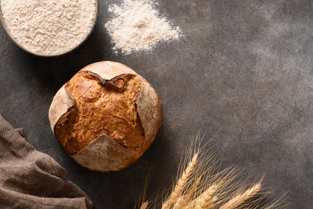 Homemade freshly baked whole grain bread on brown background. View from above. Copy space.の写真素材