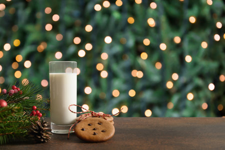 Christmas cookies in white plate and milk for Santa Claus in glass near Xmas tree. Christmas card.の写真素材