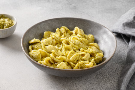 Pasta Cavatelli with sauce pesto on gray background. Close up. Italian typical cuisine.の写真素材