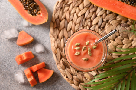 Asian traditional Papaya lassi on gray background. Freshness cold beverage made of yogurt, water, spices, fruits and ice. Popular beverage in India and Sri lanka.の写真素材