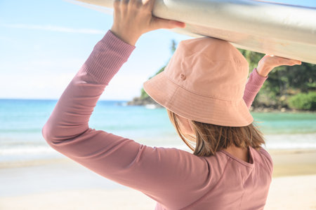 Young woman surfer with surfboard going to surfing. Close up. Oudoors. Copy space.の写真素材
