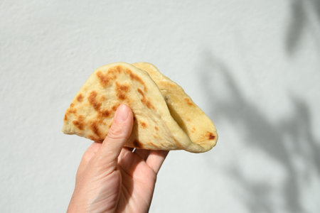 Authentic Sri Lankan Pol Coconut Roti in hand. Traditional recipe flat bread with red onion and...