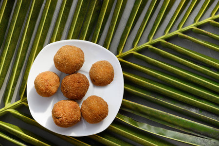 Authentic Sri Lankan cutlets snack street foods, short eats in white plate made with tuna, potatoes, onion and deep fried on palm leaf. Top view, copy space.の写真素材