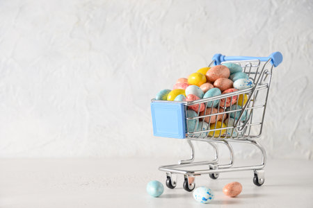Easter composition with colorful pastel chocolate eggs in shopping trolley on white background. Copy space. Close up. Happy Easter. Greeting card.の写真素材