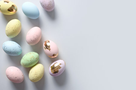 Happy Easter banner with pastel decorative eggs on gray background. View from above. Flat lay....