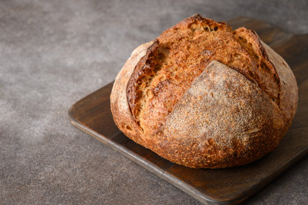 Loaf of wholegrain sourdough bread on gray background. Close up.の写真素材
