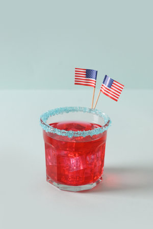 Patriotic red pomegranate margarita on blue background. Vertical format. Close up. Rim your festive beverages in blue sugar for popping July 4th cocktail.の写真素材