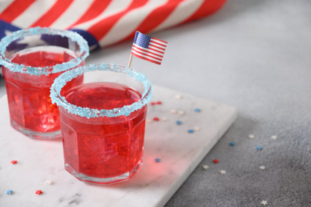 Patriotic red pomegranate margarita cocktail on gray background. Festive beverages for Independence Day July 4th. Close up. Copy space. Rimmed drinks.の写真素材