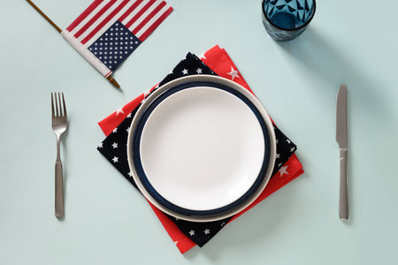 Patriotic table setting with USA flag and decoration in national flag colors on blue background. Independence Day. Happy Memorial Day. View from above.の写真素材