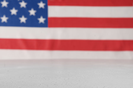 American flag as blurred background and white table. Copy space. 4th of July celebration concept.の写真素材
