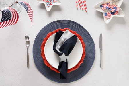 Patriotic table setting with american flag and decoration in national flag colors on white background. Independence Day. Happy Memorial Day. View from above. Copy space.の写真素材