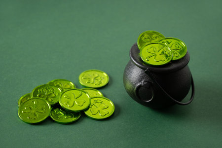 Banner St. Patrick's day black pot, treasure of leprechaun, pot full of green coins on festive green background. Close up.の写真素材