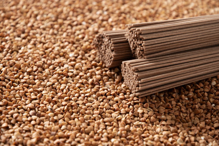 Raw buckwheat noodles soba on grain. Space for text. Healthy vegan diet. Close up. Alternative gluten free pasta.の写真素材